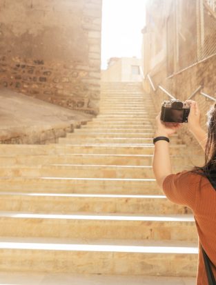 attractive asian female traveller tourism hand use camera sightseeing old stone stair hallway in cartagena spain with happiness and cheerful travel journey concept